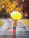 Woman with umbrella taking walk in autumn park