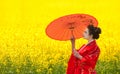 Woman with umbrella in the yellow flowering field Royalty Free Stock Photo