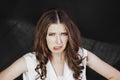 Woman with uncombed hair make a grimace in white shirt stand studio shoot on dark background. Royalty Free Stock Photo