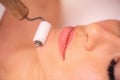 Woman undergoing a chin massage with facial massaging beauty roller Royalty Free Stock Photo