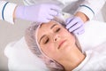 Woman undergoing face biorevitalization procedure in salon.