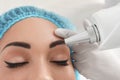 Woman undergoing laser tattoo removal procedure in salon