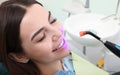 Woman undergoing teeth whitening procedure in clinic