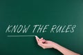 Woman underlining phrase Know the rules on chalkboard, closeup