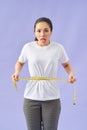Woman unhappy with her body, the diet, the body measures the isolated violet background
