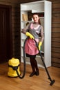 Woman in uniform and gloves with vacuum cleaner