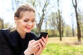 Woman with unkempt hair looking into smartphone smiling