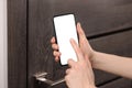 Woman unlocking door using smartphone, closeup view