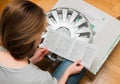 Woman unpacking car hub covers reading manual