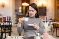 Woman unpleasantly surprised by taste of espresso in coffee house Royalty Free Stock Photo