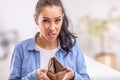 Woman with unsure facial expression holds empty waller or purse open with no money in it