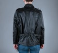 A woman in unzipped black biker leather jacket. Back view. Royalty Free Stock Photo