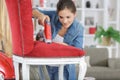 Woman upholstering chair in workshop