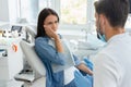 Woman is upset of pain looking at dentist in dentist office