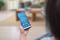 Woman use climate control app on a phone in the living room to adjust temperature and ventilation