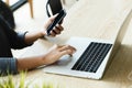 Woman use laptop and smart phone on desk in office place