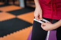 Woman use measuring tape to measure her leg after exercise at gym, concept of sport and copy space Royalty Free Stock Photo