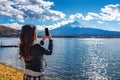 Woman use mobile phone take a photo at Fuji mountains, Kawaguchiko lake in Japan