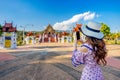 Woman use mobile phone take a photo at Ho kham luang northern thai style in Royal Flora ratchaphruek in Chiang Mai,Thailand.