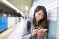 Woman use of mobile phone in train platform Royalty Free Stock Photo