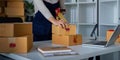 Woman use scotch tape to attach parcel box to prepare goods for the process of packaging, shipping, online sale internet