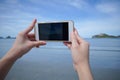 Woman use smart phone take a photo of the sea in Prachuapkhirikhan ,thailand real picture in monitor