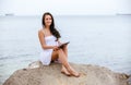 Woman use touch pad tablet pc internet technology sitting beach Royalty Free Stock Photo