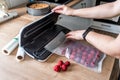 Woman use vacuum sealer for long-term storage of products. Vacuum strawberries packaging for long-term storage