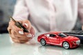 woman uses a calculator while signing a contract document for car insurance. Royalty Free Stock Photo