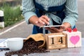 A woman uses a laptop and drinks coffee in nature with a gift box with a heart shape and a wooden calendar. The concept of love Royalty Free Stock Photo