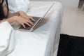 Woman uses a laptop to work over Internet in her bedroom because of coronavirus pandemic and company wants to work from home to be