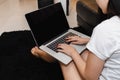 Woman uses a laptop to work over Internet in her bedroom because of coronavirus pandemic and company wants to work from home to be