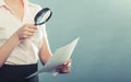 Woman uses magnifying glass to check contract Royalty Free Stock Photo