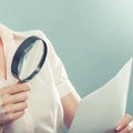 Woman uses magnifying glass to check contract Royalty Free Stock Photo