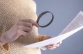 Woman uses magnifying glass to check contract Royalty Free Stock Photo