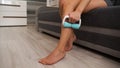 A woman uses a massage roller to massage her legs. Massage for elastic skin