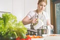 Woman uses a mixer to prepare a meal.