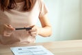 Woman uses a mobile smartphone to scan the QR code from the invoice in the documents for the bills. Payment and scan concept