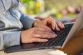 Woman uses a notebook computer outdoors close-up. The background is blurred Royalty Free Stock Photo