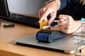 A woman uses a payment card terminal to shop online and shows a fig with his other hand