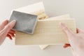 Woman uses a sandpaper to restore wooden surface