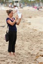 Woman Uses Tablet Computer To Capture Family Images On Beach