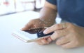 A woman uses a touchscreen smartphone to communicate. Connect the information in the online world at a coffee shop according to Royalty Free Stock Photo