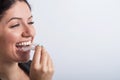 A woman uses transparent retainers to whiten teeth