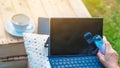 Woman using alcohol nano mist sprayer cleaning a laptop to prevent the virus and bacterias in garden. Quarantine for coronavirus