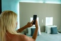 Woman Using App On Mobile Phone To Control Central Heating Temperature In House Royalty Free Stock Photo