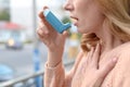 Woman using asthma inhaler outdoors, closeup. Royalty Free Stock Photo