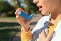 Woman using asthma inhaler outdoors Royalty Free Stock Photo