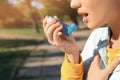 Woman using asthma inhaler outdoors Royalty Free Stock Photo