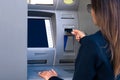 Woman using an ATM machine. Withdrawing cash money from credit or debit card at bank machine Royalty Free Stock Photo